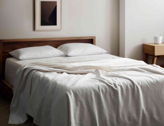 Cream Organic Cotton Blanket on a minimalist bed, GOTS certified and hypoallergenic, perfect for sustainable and cozy bedding solutions.