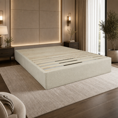 A modern bed frame made for supporting heavy Latex Mattresses , light beige upholstery shown in a styled bedroom setting with a matching textured rug, bedside tables, and warm ambient lighting.