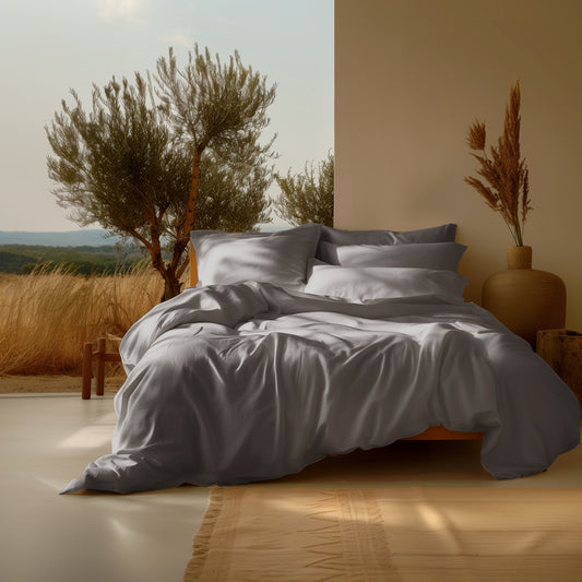 Sleep & Beyond grey organic GOTS certified cotton duvet cover on a bed with matching pillows in a sunlit room