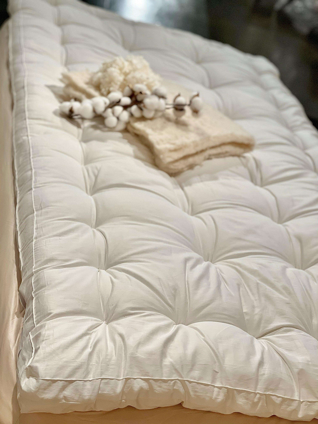 Wool and Latex Topper by Sleep & Beyond - 3 inch thickness shown on a bed with tufted surface and soft cotton cover for luxurious comfort.